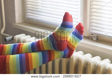 Heavy Duty Radiator - Central Heating. Woman With Colorful Socks Enjoying Winter In Warm, Cozy Room