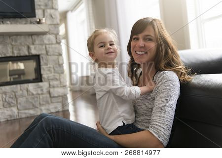 Happy Mother With Her Baby Daughter In The Living Room At Home