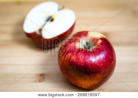Red Apple Next To Slices Of Another Apple.