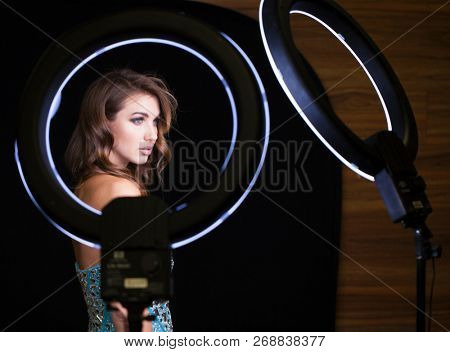 Studio portrait young woman in blue dress with ring flash effect. Round LED Circle Lamp