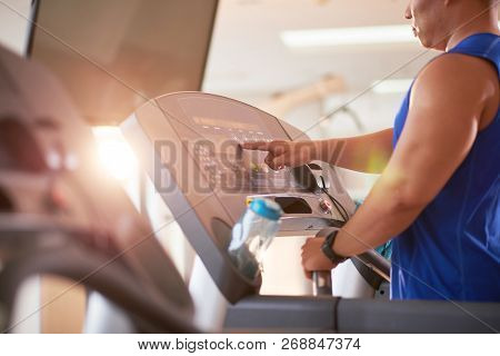 Sporty Man Choosing Program On Threadmill Before Running
