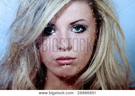 Triste joven hermosa y una gotas de lluvia en la ventana