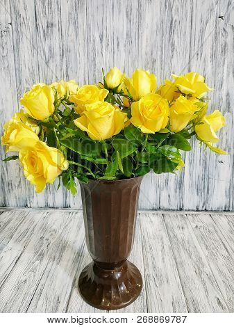 Pot With A Bouquet Of Yellow Roses On A White Wooden Background Close-up. Work In A Flower Shop