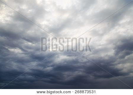 Cloudy Rainy Summer Day. Through The Rain Clouds Visible Part Of The Blue Sky And The Rays Of The Su