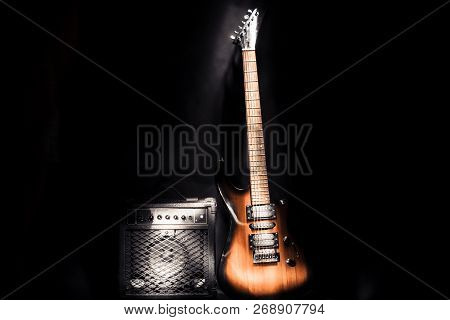 Electric Guitar And Amplifier Isolated On A Dark Background.
