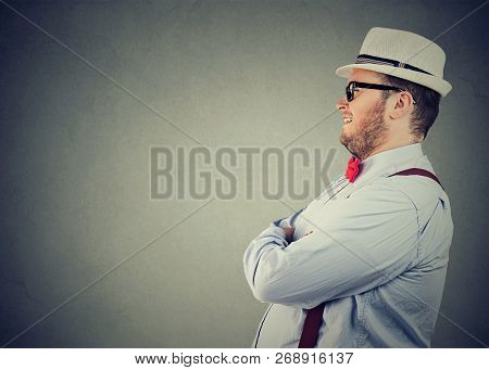 Side View Of A Chubby Happy Man In Elegant Outfit With Bow Tie And Straw Hat Looking Away Confidentl