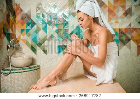 Attractive Girl Applying Foam And Sitting On Hammam Table In Turkish Bath
