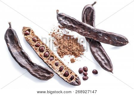 Carob pods and carob powder on the white background.