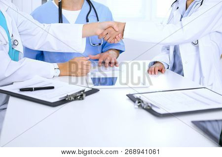 Two Doctors Shaking Hands To Each Other At Meeting. Teamwork And Agreement In Medicine