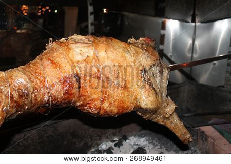 A Whole Lamb Roasting On A Spit