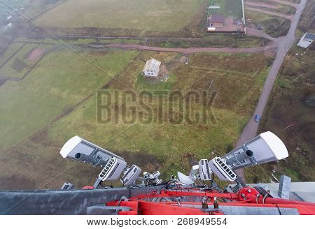 Red Telecommunication Tower Or Mast With Microwave, Radio Panel Antennas, Outdoor Remote Radio Units