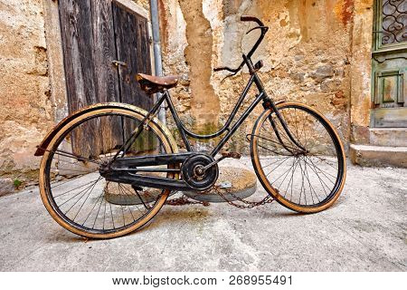Old retro bicycle on vintage street in Croatia background aged wall and wooden door. City Lovran.