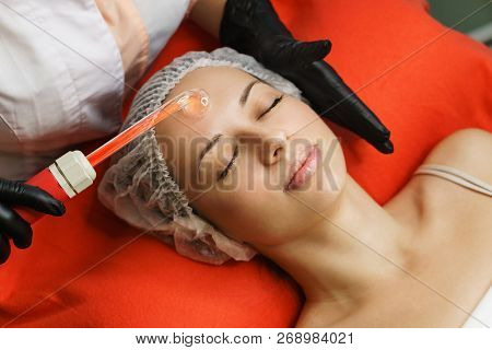 Hardware Cosmetology. Beautician Violet Ray Face Of A Young Woman. Skin Pore Cleansing. Anti-aging T