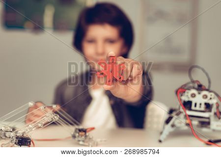 Boy Sitting At Desk And Constructing Robot At Home. Young Boy In Shirt. Indoor Joy. Modern Hobby Con