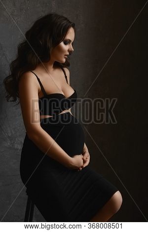 Young Pregnant Woman In Black Bra And Black Skirt. Motherhood, Pregnancy, Copy Space. Pregnancy Fash