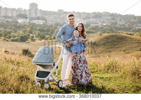 Mom, Dad And Little Girl Having Fun Outdoors In The Grass On Summer Day. Mothers, Fathers And Babys 
