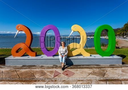Chapala, Jalisco / Mexico, January 20. 2020. Smiling Female Tourist Sitting Among Number 2020 With P