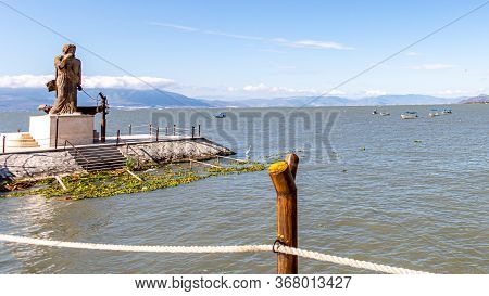Fence With Wooden Posts And Ropes On The Promenade On Lake Chapala With The Statue Of Jesus The Fish