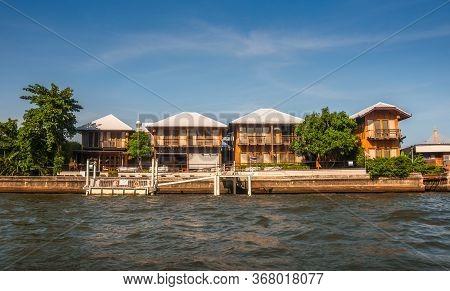 Houses On The Chao Phraya Riverside At Sunny Day In Bangkok, Thailand