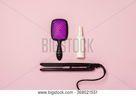 Hair Straightener, Comb And Hair Care Product On A Pink Background. Concept Of Hair Care, Hairstyle,