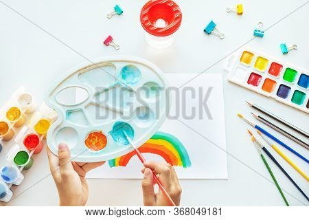 Girl Painting Rainbow On Paper During Covid-19 Quarantine At Home.