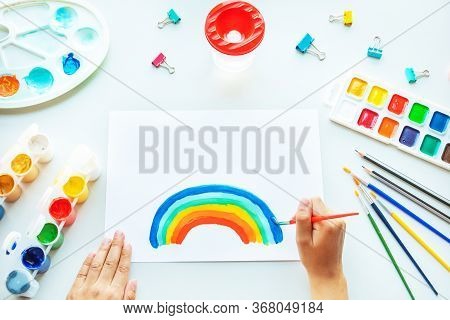 Girl Painting Rainbow On Paper During Covid-19 Quarantine At Home.