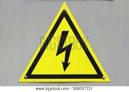Sign Of Danger Of Electric Shock On White Isolation Background. Black Lightning Against A Yellow Tri