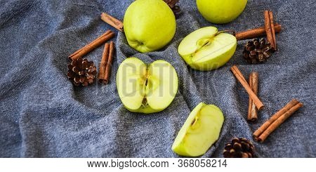 Green Golden Apples Or Granny Smith With Cinnamon Sticks Pine Fir Cones On Kitchen Towel, Preparing 