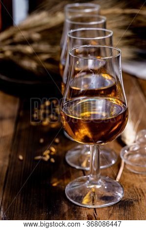 Tasting Glasses With Aged Scotch Whisky Or American Bourbon On Old Dark Wooden Vintage Table With Ba