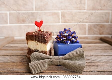 Happy Fathers Day Greeting With Blue Gift Box With Tiebow And A Cupcake Decorated With Red Heart On 