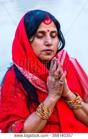 Kathmandu,nepal - November 1,2019: Hindu Devotee Offering Prayers To Sun God Standing In Water Accor