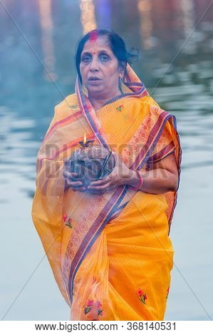 Kathmandu,nepal - November 1,2019: Hindu Devotee Offering Prayers To Sun God Standing In Water Accor