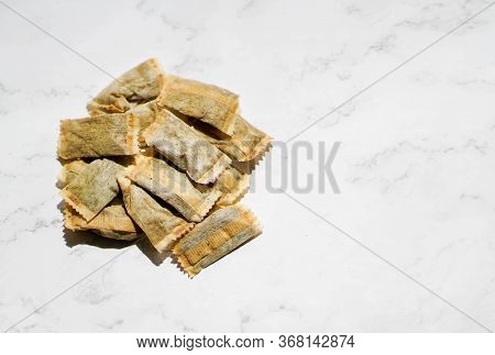 Swedish Snus Chewing Tobacco On A White Granite Background.