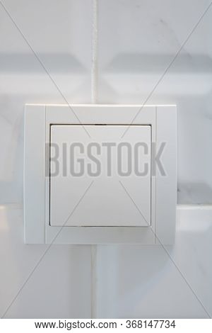 Close Up View Of White Electric Light Switch On White Tile. Building Construction Elements Concept, 