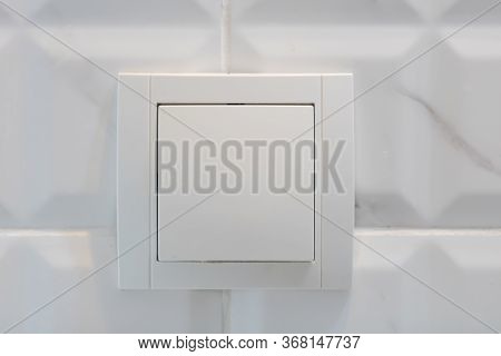 Close Up View Of White Electric Light Switch On White Tile. Building Construction Elements Concept, 