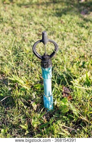 Sprinkler Watering In The Garden.on The Lawn