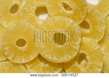 Yellow Pineapple Sweets Cut In Round Slices In Powdered Sugar.