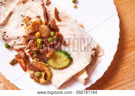 Home-cooked Shaverma. Sausage, Cucumber, Grilled Vegetables Lie On A Pita