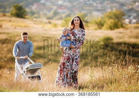 Mom, Dad And Little Girl Having Fun Outdoors In The Grass On Summer Day. Mothers, Fathers And Babys 