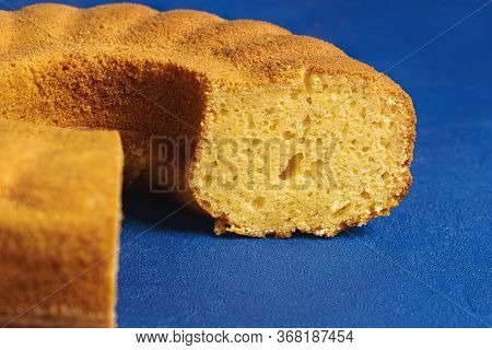 Close-up Of A Sliced Cornmeal Cake On A Blue Background. Sponge Cake Made With Cornmeal. Fest Junina