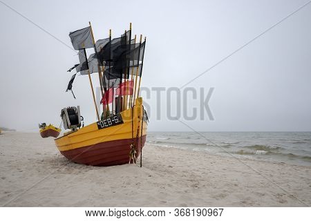 Debki, Poland- May 25, 2020: Fishing Boat On The Beach On A Cloudy And Foggy Day. Baltic Sea, Poland