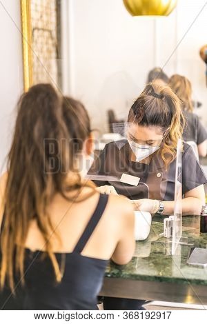 Manicure And Pedicure Beauty Salon With Security Measures, Masks And Plastic Screens. Reopening Afte
