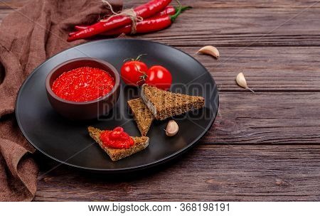 Ajvar Or Pindjur Red Vegetable Spread Or Pepper Paprika And Tomato Mousse In A Clay Bowl In A Black 