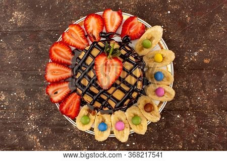 A Top View Yummy Pancakes With Fruits On The Brown Desk