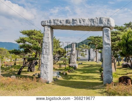 Gimcheon, South Korea; May 24, 2020: Gate Structure Made Of Large Flat Stones With Rock Statue Of Ko
