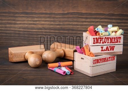 Employment Law And Compensation Concept. Colored Papr Scrolls In Wooden Boxes On Dark Wooden Backgro