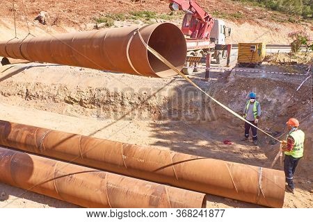 Workers Are Laying Metal Culverts Under The Highway Under Construction