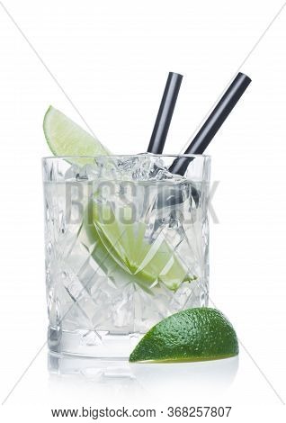 Gimlet Cocktail In Crystal Glass With Ice Cubes And Straw And Lime Slices On White Background With L