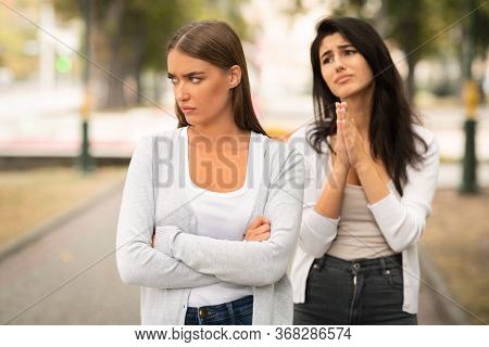 Girl Begging Offended Female Friend To Remain Friends After Quarrel Standing Outdoors. Selective Foc