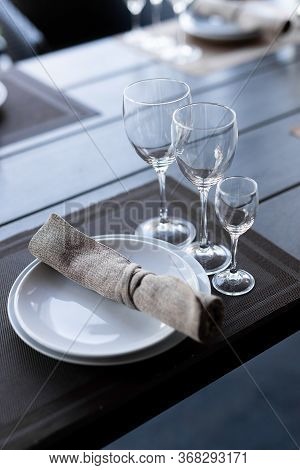 Served Wooden Table With Three Empty Wineglasses